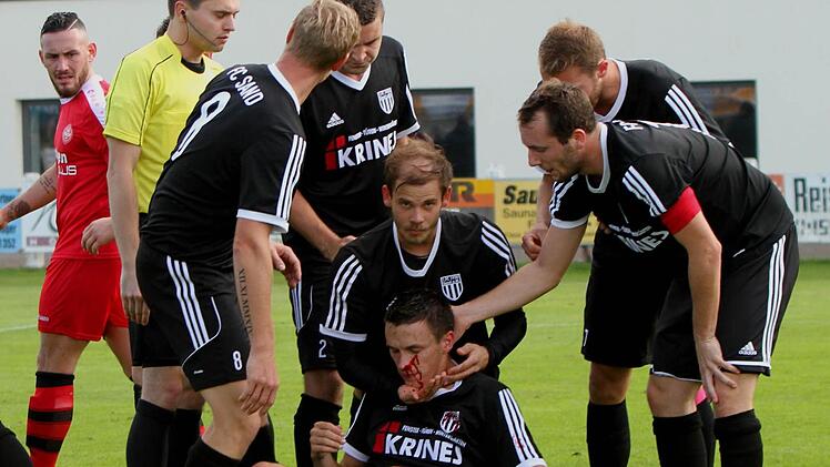 Der verletzte Danny Schlereth (am Boden), umringt vom Schiedsrichter und seinen Mannschaftskameraden Stefan Nöthling, Andre Schmitt, dem zweifachen Torschützen Sebastian Wagner, Andre Karmann und FC-Kapitän Daniel Krüger.