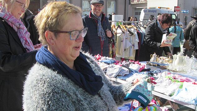 F&uuml;r die Enkel sucht die Flohmarktbesucherin Kindertextilien. Foto: Winfried Ehling