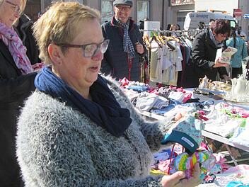 Für die Enkel sucht die Flohmarktbesucherin Kindertextilien. Foto: Winfried Ehling