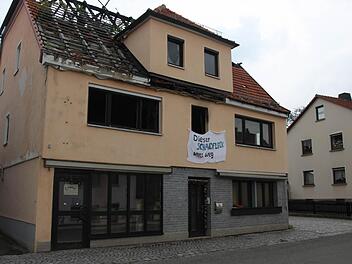 Von den Spuren des Brandes gekennzeichnet, steht das Gebäude auch noch vier Jahre nach dem Feuer in Johannisthal. Seit kurzem ist es mit einem Betttuch versehen, das die Aufschrift trägt: "Dieser Schandfleck muss weg". Fotos: Corinna Igler (2), Archiv (1)