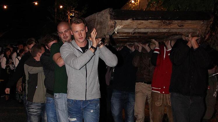 Rund 20 starke Limmersdorfer trugen am Dienstagabend die "Lizza", die Treppe zur traditionsreichen Tanzlinde, in ihren Schuppen. Dort wartet sie nun bis zur nächsten Kerwa. Fotos: Katharina Müller-Sanke