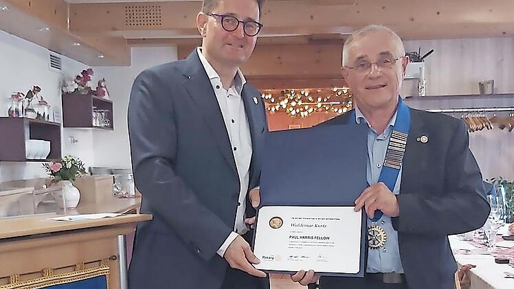 Der bisherige Präsident des Rotary Clubs Höchstadt, Harald Laubinger (links), überreicht dem Clubpräsidenten des neuen rotarischen Jahres, Waldemar Kurtz, seine Amtskette sowie dessen Ehrung mit der Paul-Harris-Fellow-Nadel samt Urkunde.
