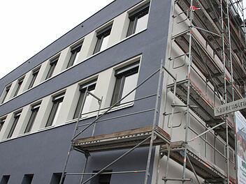 Ein Teil des Gerüstes an der Montessori-Schule ist gefallen und gibt den Blick frei auf die neue Fassade in taubenblauem Putz.  Foto: Andreas Oswald