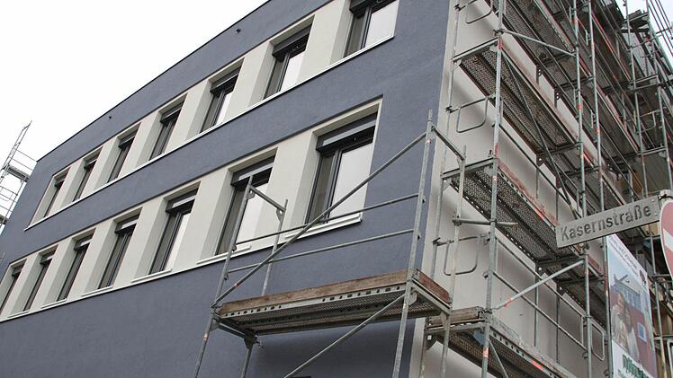 Ein Teil des Gerüstes an der Montessori-Schule ist gefallen und gibt den Blick frei auf die neue Fassade in taubenblauem Putz.  Foto: Andreas Oswald