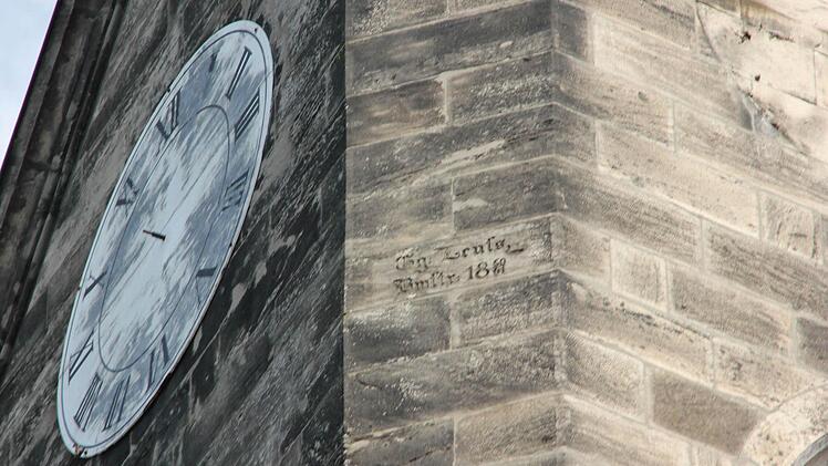 Das defekte Zifferblatt der Südseite vor dem Abnehmen. In der Mitte der Mauerstein des Baumeisters der Kirche.