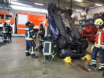 Wie setzt man welches technische Gerät ein, um aus diesem auf dem Dach liegenden Fahrzeug Menschen zu retten? Die Herzogenauracher Feuerwehrleute probten den Ernstfall.  Foto: Richard Sänger