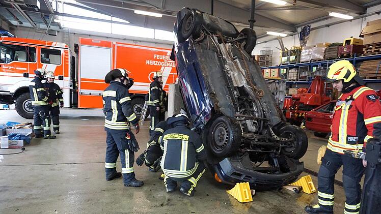 Wie setzt man welches technische Gerät ein, um aus diesem auf dem Dach liegenden Fahrzeug Menschen zu retten? Die Herzogenauracher Feuerwehrleute probten den Ernstfall.  Foto: Richard Sänger