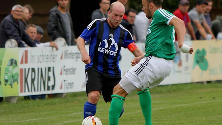 Der Sander Thorsten Schlereth (rechts) im Duell mit dem Gästekapitän Thomas Wildenauer.