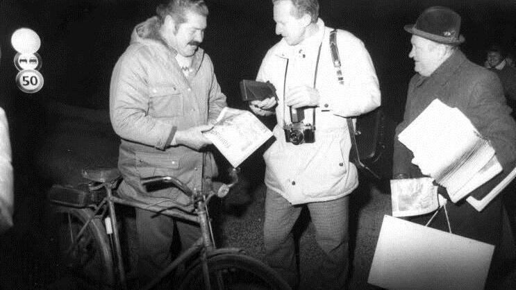 Ein Radfahrer (links) war am 18. November 1989 um 6 Uhr der erste Nutzer des Grenzübergangs bei Nordhalben. Er fuhr bei Eiseskälte mit dem Fahrrad und erhielt vom langjährigen FT-Abonnentenbetreuer Heinrich Müller (rechts) aus Wallenfels einen FT.  Foto: Friedwald Schedel