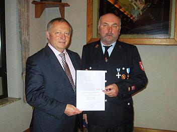 Für herausragende Leistungen übergab Landrat Thomas Bold (links) das silberne Feuerwehr-Ehrenzeichen des Freistaats an den Engenthaler Thomas Schipper.             Winfried Ehling
