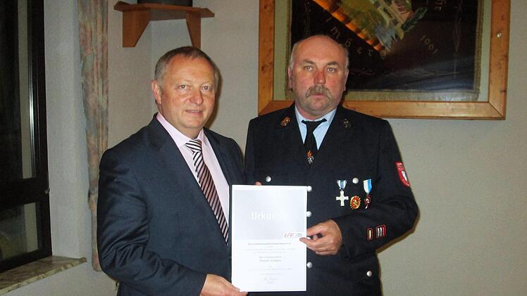 Für herausragende Leistungen übergab Landrat Thomas Bold (links) das silberne Feuerwehr-Ehrenzeichen des Freistaats an den Engenthaler Thomas Schipper.             Winfried Ehling