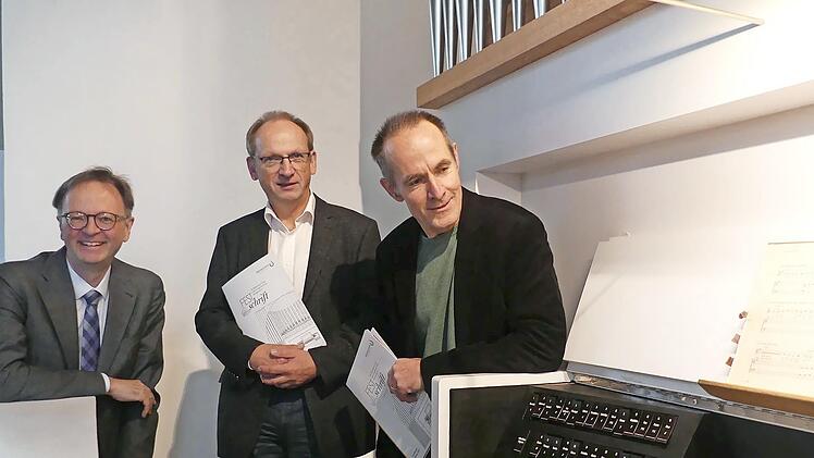 Gerald Fink sowie Stephan Krause und Joachim Stade (v. l.) von der Firma Orgelbau Waltershausen begutachten den Spieltisch der neuen Orgel.