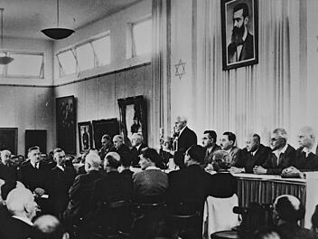 14. Mai 1948: David Ben-Gurion erklärt die Unabhängigkeit des Staates Israel unter einem Porträt Theodor Herzls.