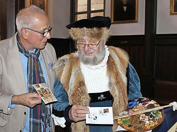 Richard Thomas (links), Besitzer des weltklassigen Cranach- Exponates, begutachtet gemeinsam mit Lucas Cranach, alias Wolfgang Eckert-Hetzel, die neue Sonderbriefmarke und den Poststempel. Foto: Mariell Dörrschmidt