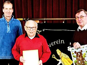 Kreisvorsitzender Jürgen Schubert (links) und der Vorsitzende des Imkervereins Kirchlauter und Umgebung, Peter Kirchner (rechts), ehrten Werner Heckelmann mit der Urkunde in Gold des Imkerbundes.  Foto: gg