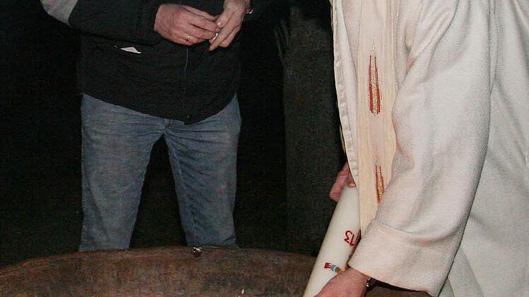 Pfarrer Wolfgang Oertel entzündete am Osterfeuer die große Kerze - und brachte das Licht in die dunkle Kirche.