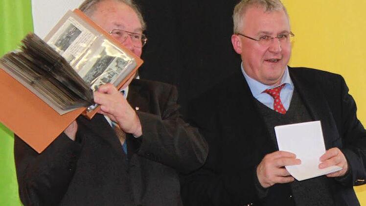 Dr. Klaus Reder, Bezirksheimatpfleger, übergab den Ordner mit Ansichtskarten aus dem Altlandkreis Ebern an Ingo Hafenecker, der ihn stolz präsentierte. Foto: Katharina Becht