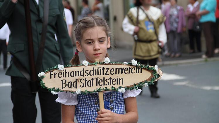 Mädchen mit geschmücktem Schild im Festzug
