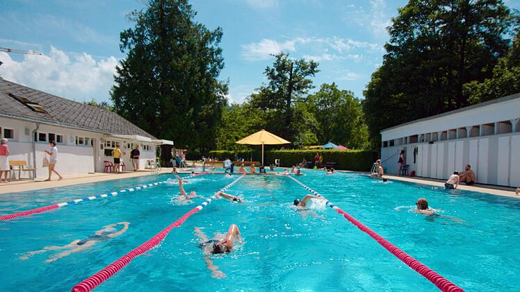 Badegäste schwimmen im Freiburger Lorettobad. Das Bad von 1842 gilt als ältestes Freibad Deutschlands.