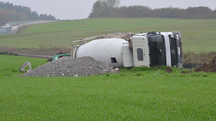 Der umgekippte Betonmischer liegt noch immer nahe dem Südportal des ICE-Tunnels Reitersberg bei Unterwohlsbach im Acker. Am Transportbehälter ist das Loch zu erkennen, das Arbeiter in die Trommel schnitten, um den Beton abzupumpen. Foto: Rainer Lutz