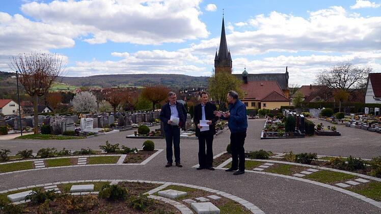 Landschaftsarchitekt Jörg Czerwonka (rechts) erläutert Pfarrer Marianus Schramm und Litzendorfs Bürgermeister Wolfgang Möhrlein die neue Gestaltung des Friedhofs, hier insbesondere den Urnenkreis für die Erdbestattung von Urnen. Foto: Andrea Spörlein