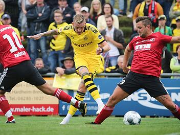 Dortmunds Marius Wolf (Mitte) setzt sich gegen die Kreisliga-Kicker des FC Schweinberg, Christoph Knörzer (links) und Andreas Michel, durch. Beim 10:0-Erfolg seines BVB erzielte der Einberger den Treffer zum 5:0.  Foto: Karl-Josef Hildenbrand/dpa