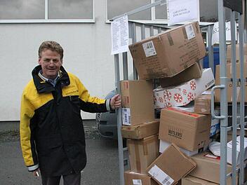 Manfred Pauli zieht den Paketwagen zu seinem Caddy. Knapp 60 Kisten muss er diesmal einladen. Fotos: Vanessa Schneider