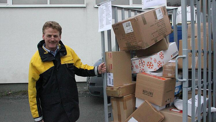 Manfred Pauli zieht den Paketwagen zu seinem Caddy. Knapp 60 Kisten muss er diesmal einladen. Fotos: Vanessa Schneider
