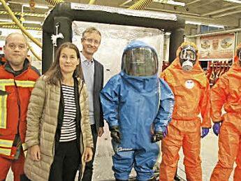 Bei der Übergabe (v. l.): FFW-Kommandant Holger Köferlein, Christiane Meyer, Kennametal-Werkleiter Thomas Reindl und drei Mitglieder der Feuerwehr in Chemie-Schutzausrüstung Foto: Kennametal