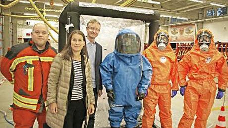Bei der Übergabe (v. l.): FFW-Kommandant Holger Köferlein, Christiane Meyer, Kennametal-Werkleiter Thomas Reindl und drei Mitglieder der Feuerwehr in Chemie-Schutzausrüstung Foto: Kennametal