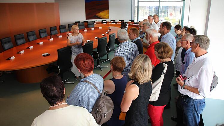 Eine Mitarbeiterin des Besucherdienstes zeigt den Kabinettstisch im Kanzleramt. Foto: Ralf Ruppert