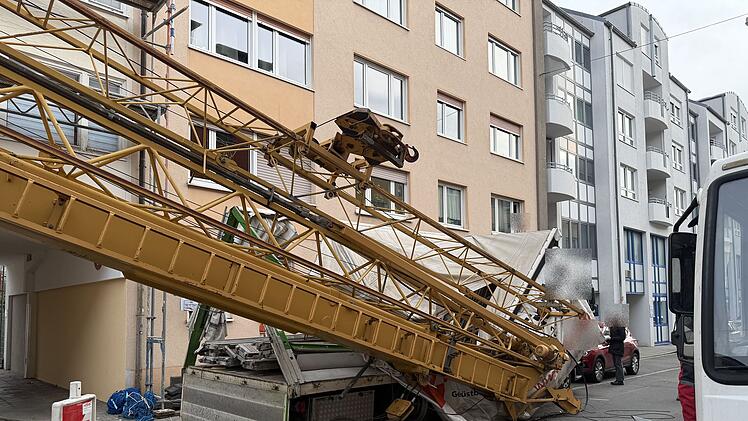 Unfall auf Baustelle: Baukran kippt auf Lastwagen