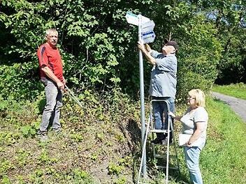 Rigobert Weyer (auf der Leiter) ist seit 45 Jahren für die Wegemarkierung des Rhönklub Zweigverein Bischofsheim zuständig. Seit zwei Jahren betreut der Bischofsheimer Zweigverein ach die Naturpark-Rundwege. Mit im Bild Frank Gerken (links) und Gabriele Weyer (rechts).  Foto: Marion Eckert