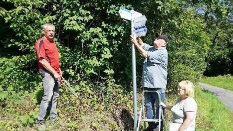 Rigobert Weyer (auf der Leiter) ist seit 45 Jahren für die Wegemarkierung des Rhönklub Zweigverein Bischofsheim zuständig. Seit zwei Jahren betreut der Bischofsheimer Zweigverein ach die Naturpark-Rundwege. Mit im Bild Frank Gerken (links) und Gabriele Weyer (rechts).  Foto: Marion Eckert