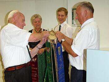 Günther Weber, Inge Winkler, Florian Eichner und Altbürgermeister Heinz Burges (von links) beim Anheften der Fahnenbänder an die neue Vereinsfahne der Schützen. Foto:Werner Oetter