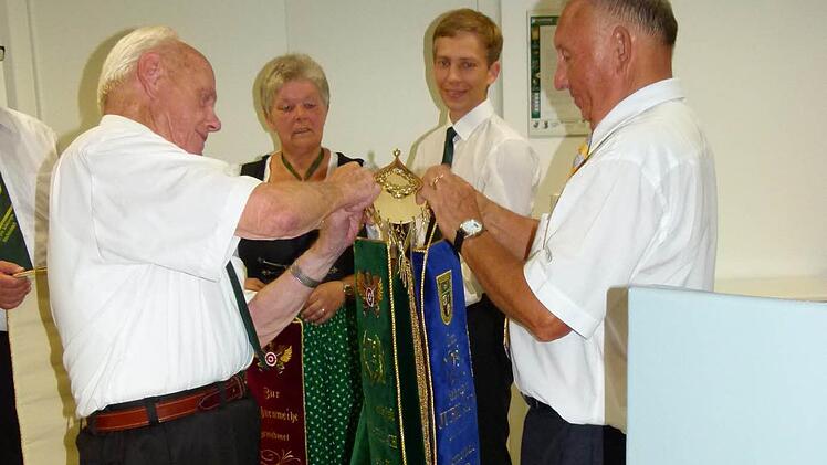Günther Weber, Inge Winkler, Florian Eichner und Altbürgermeister Heinz Burges (von links) beim Anheften der Fahnenbänder an die neue Vereinsfahne der Schützen. Foto:Werner Oetter
