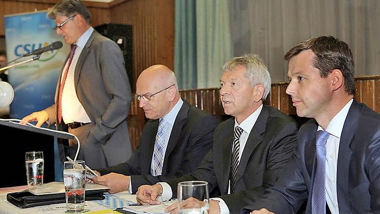 Kreisvorsitzender Thomas Silberhorn MdB (rechts) und Wahlleiter Johann Kalb (daneben) verfolgen mit Landrat und Bezirkstagspräsident Günther Denzler den Rechenschaftsbericht des Landtagsabgeordneten Heinrich Rudrof (stehend).  Foto:  Matthias Hoch