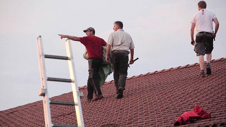 Einsatzkräfte des Technischen Hilfswerkes dichten die Lecks auf dem Dach des Rewe-Getränkemarktes in Neunkirchen ab. Foto: Josef Hofbauer