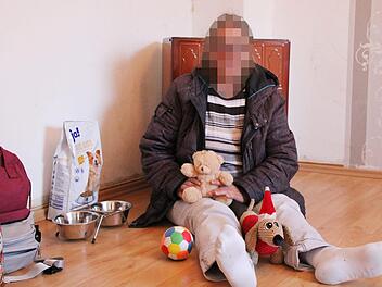 Rosalinde Eckart (Name geändert) sitzt mit dem Spielzeug ihrer Hündin Lotte auf dem Fußboden ihres Schlafzimmers. Sie hofft jeden Tag, dass sie das Tier wiederbekommt. Foto: Ulrike Müller