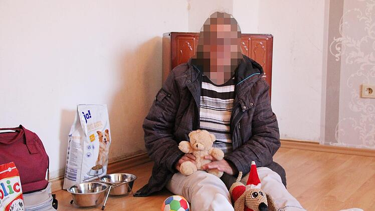 Rosalinde Eckart (Name geändert) sitzt mit dem Spielzeug ihrer Hündin Lotte auf dem Fußboden ihres Schlafzimmers. Sie hofft jeden Tag, dass sie das Tier wiederbekommt. Foto: Ulrike Müller