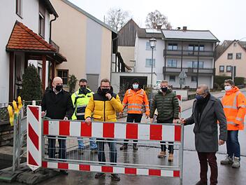 Bürgermeister Michael Kastl, Martin Holland-Nell (Abwasserverband Saale-Lauer), Ortssprecher Fabial Nöth, August Ullrich (Ullrich-Bau) Oberbauleiter Steffen Kiesel, stellvertretender Landrat Emil Müller und Bauleiter Markus Wehner räumen schon mal probeweise die Absperrung weg. Foto: Thomas Malz