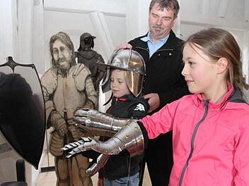 Hanna und Leo tragen Ritterhelm und Panzerhandschuh. Mit im Bild Kastellan Günther Schwarzott. Fotos: Alexander Hartmann