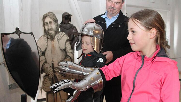 Hanna und Leo tragen Ritterhelm und Panzerhandschuh. Mit im Bild Kastellan Günther Schwarzott. Fotos: Alexander Hartmann