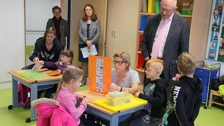 Bei seinem Besuch des Neubaus des oberfränkischen Förderzentrums für Schüler mit Körperbehinderungen auf der Bertelsdorfer Höhe ging Bezirkstagspräsident Dr. Günther Denzler (im Hintergrund rechts) am Dienstag auch in die erste Klasse. Während der Stationenarbeit brachten Karin Sladky (am rechten Tisch) und Katrin Lösch (am Tisch links) gerade den ABC-Schützen Adrian, Leon, Laura und Lisa (von rechts) den Buchstaben "I" näher. Angela Trautmann-Janovsky (Sozialverwaltung, rechts vorn) sowie Dr...