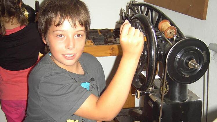 Dominik erkundet in den Flößerstuben Friesen eine alte Nähmaschine.