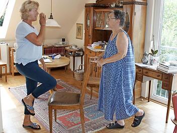 Angelika Fuchs (l.) zeigt Annemarie Jörgensen in deren Haus Übungen zur Sturzprophylaxe. Foto: Carmen Schwind