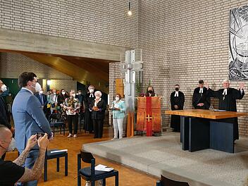 Landesbischof Heinrich Bedford-Strohm (rechts) spricht beim Entwidmungsgottesdienst in St. Lukas die Abschiedsworte. Die Mitglieder des Kirchenvorstands stehen schon bereit, die liturgischen Gegenstände hinaus zu bringen. Foto: Simone Bastian