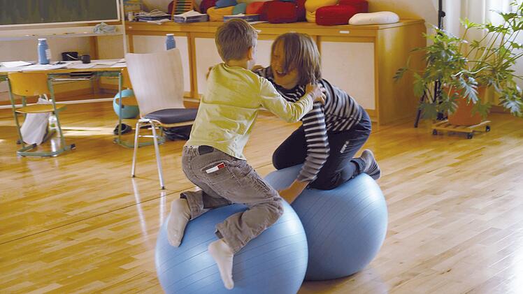 Zwei Kinder gemeinsam spielen auf Hüpfbällen