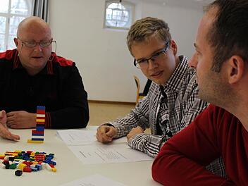 In der Probephase: Michel, Fabian und Thorsten (von links) diskutieren das beste Vorgehen fürs Bauen eines Turms aus Legosteinen. Foto: Bastian Girg