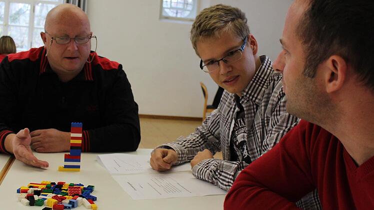 In der Probephase: Michel, Fabian und Thorsten (von links) diskutieren das beste Vorgehen fürs Bauen eines Turms aus Legosteinen. Foto: Bastian Girg